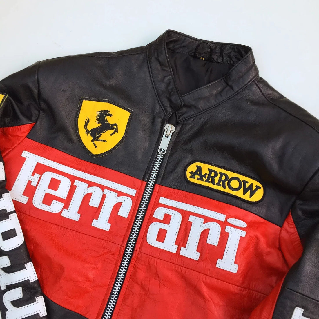 Black, red, and white Ferrari jacket with logos on a white background