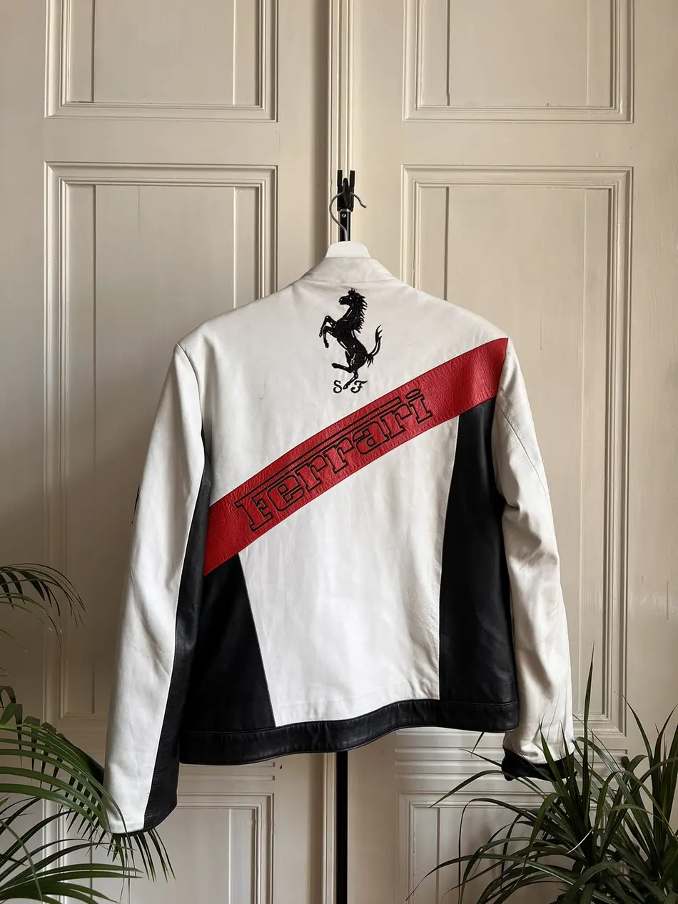 Front view of a white, black, and red leather Ferrari Formula 1 World Championship racing jacket with Bridgestone and Mobil 1 logos.